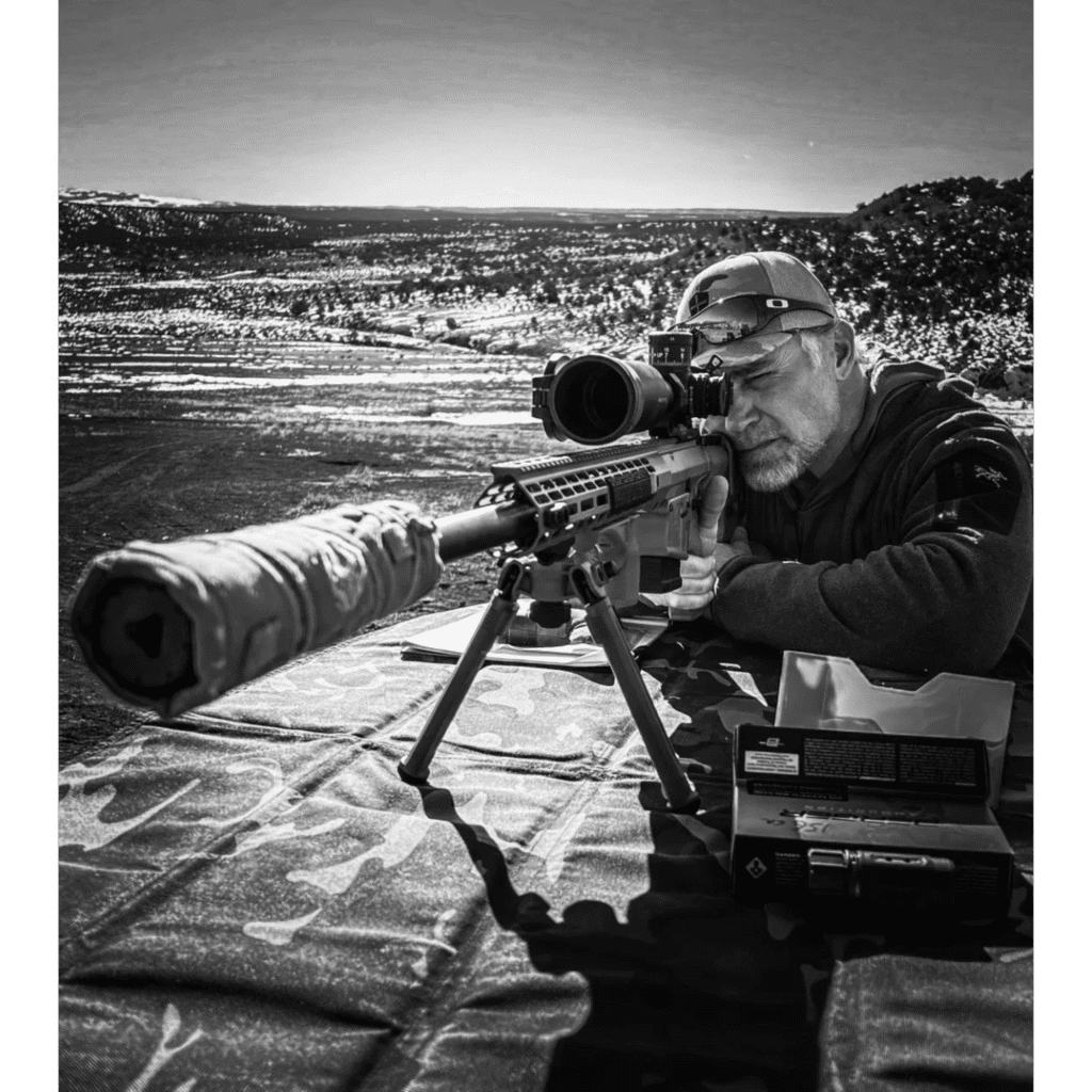 A man with a rifle and a camera.